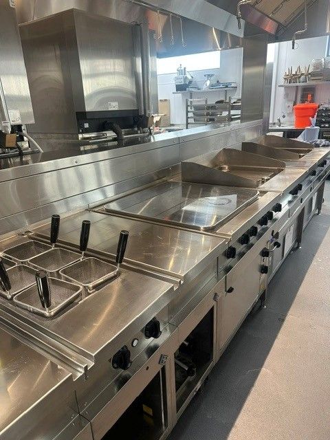 Completed stainless steel cooking suite with fryers and ranges in the AFCB Performance Centre kitchen
