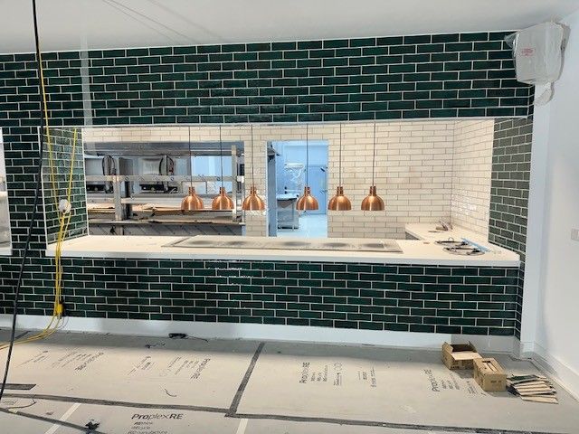 AFCB Performance Centre servery wall during installation, with protected floor